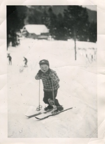1950s Kid smiling with lodge in back