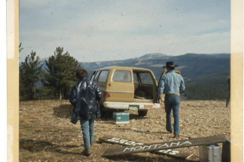 1974 Film Crew at Showdown loading uo suburban with signs on ground
