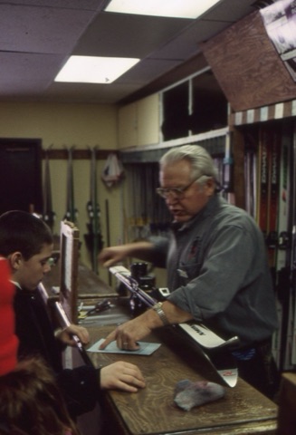 1990s Klaus Ahmels — Rental Shop — Klaus Ahmels fitting skiis with kid