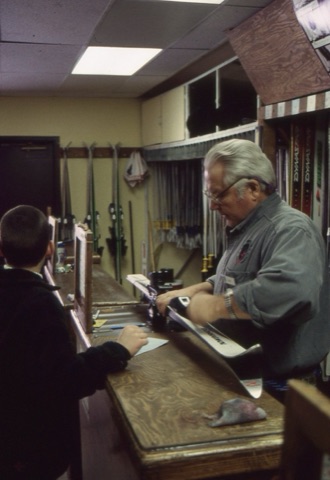 1990s Klaus Ahmels — Rental Shop — Klaus Ahmels fitting skis with kid