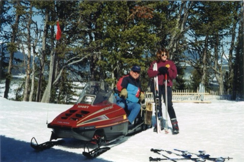 1990s Joe Pinski and unknown woman with snowmobile on top the mountain