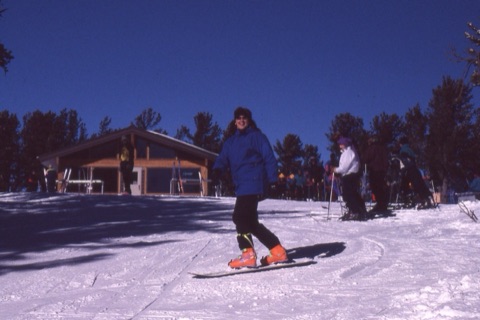 1990s Kathy Sulser snowboarding near top of mountain