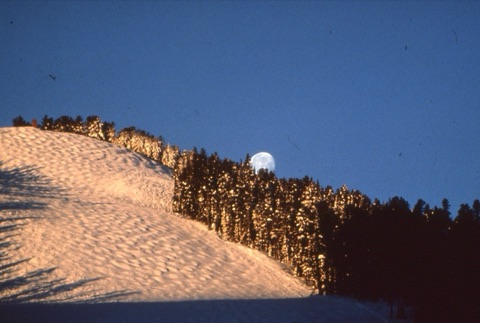 1990s Scenic moon rises above mountain with moguls