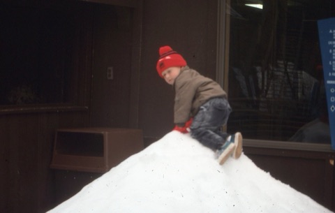 1990s unknown kid climbing on snow near lodge