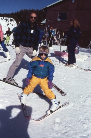 1990s unknown kid skiing and unknown man behind him near lodge