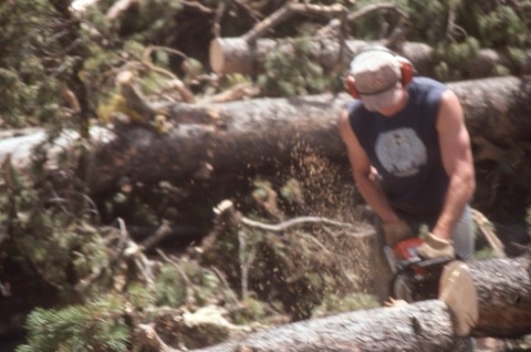 1990s unknown man cutting logs on new run