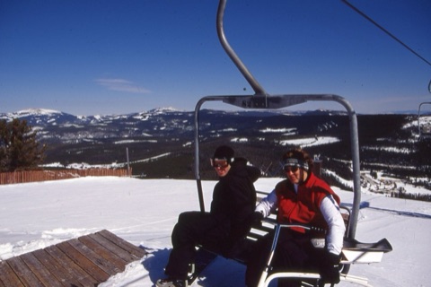 1990s unknown man, and Kathy Sulser with snowbike on triple chair