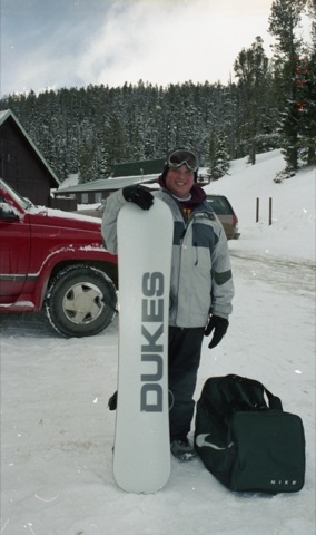 2000s Eric Hoxter with snowbaord near lodge.