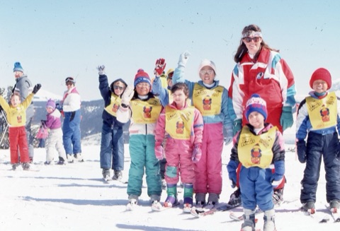 1990s unknown ski instructor with Ski Wee class on top the mountain