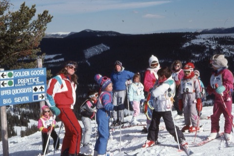 1990s unknown ski instructor with learning class on top mountain