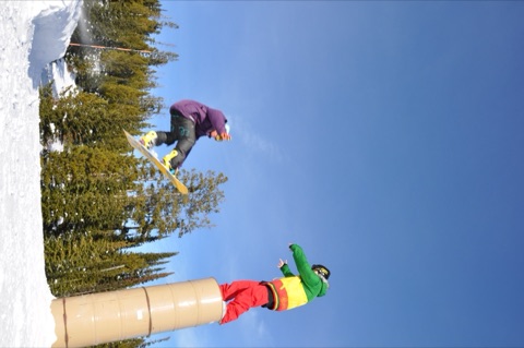 2010 Derek Tice jumping with Terrance Haverland standing on top barrels- terrain park event.jpg
