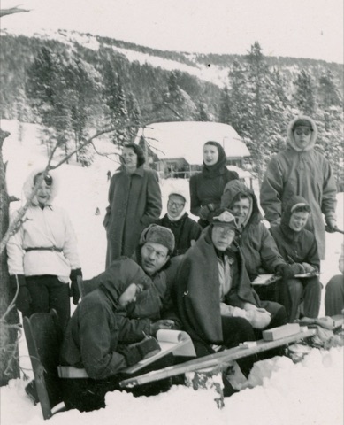 1951 Group of people near lodge, one keeping score