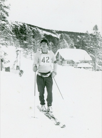 1951 Man skiing near lodge
