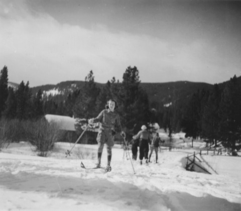1930s-40s A young woman in knickers by a log building