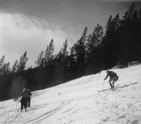 1930s-40s Skiers climbing under three overhead wires