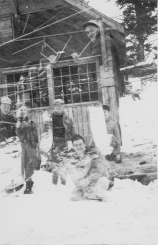 1940s A double exposure of a board hut with boys