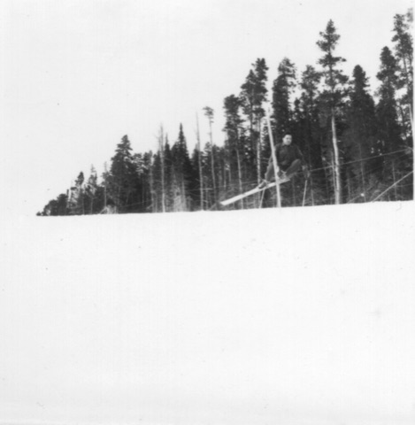 1940s A skier in the air beside a pole