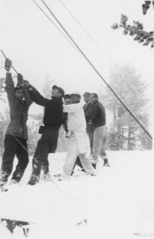 1940s Six men hauling a tow rope in falling snow