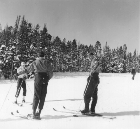 1940s Three skiers in the sun before snowy spruce
