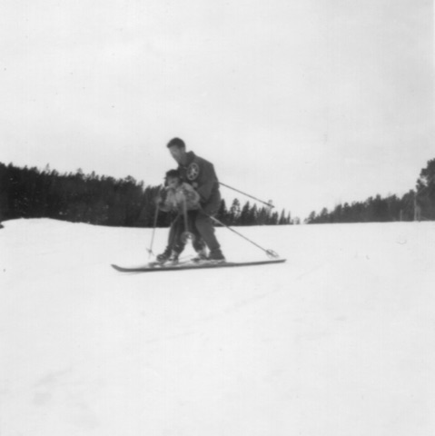1940s-50s A man skiing with a small child