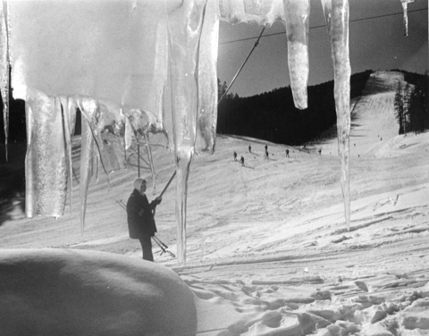 1950s-60s A skier holding a Poma bar, through the icicles